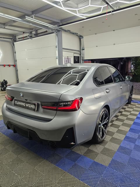 Mat sivi BMW straga s desne strane, u staklu se zrcale stropna svjetla